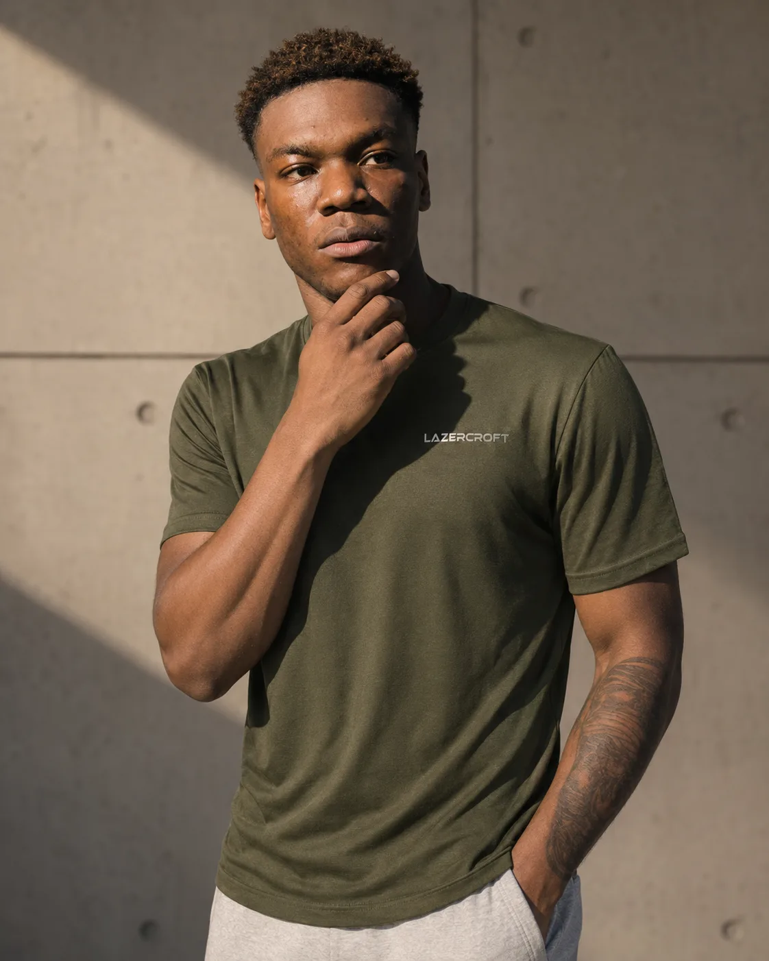Athlete wearing an olive Lazercroft training tee in sunlight